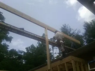 Carpenter setting a ridge beam over a new addition frame — Ice Dam Removal by Roofing Brothers in South Londonderry