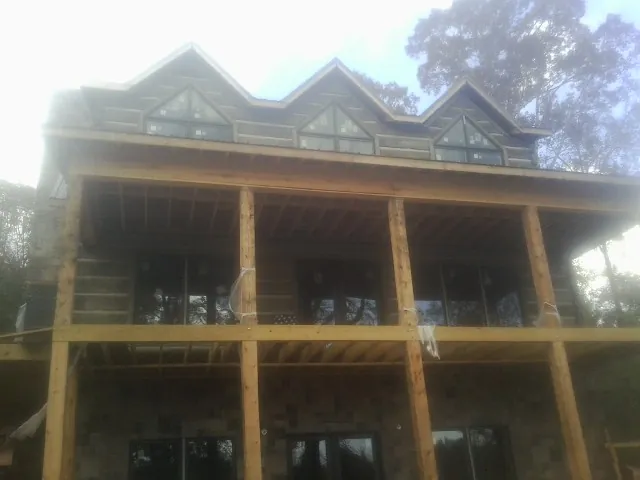 Dormers and porch framing on a large log home under construction — Roof Coating work by our crew in South Londonderry