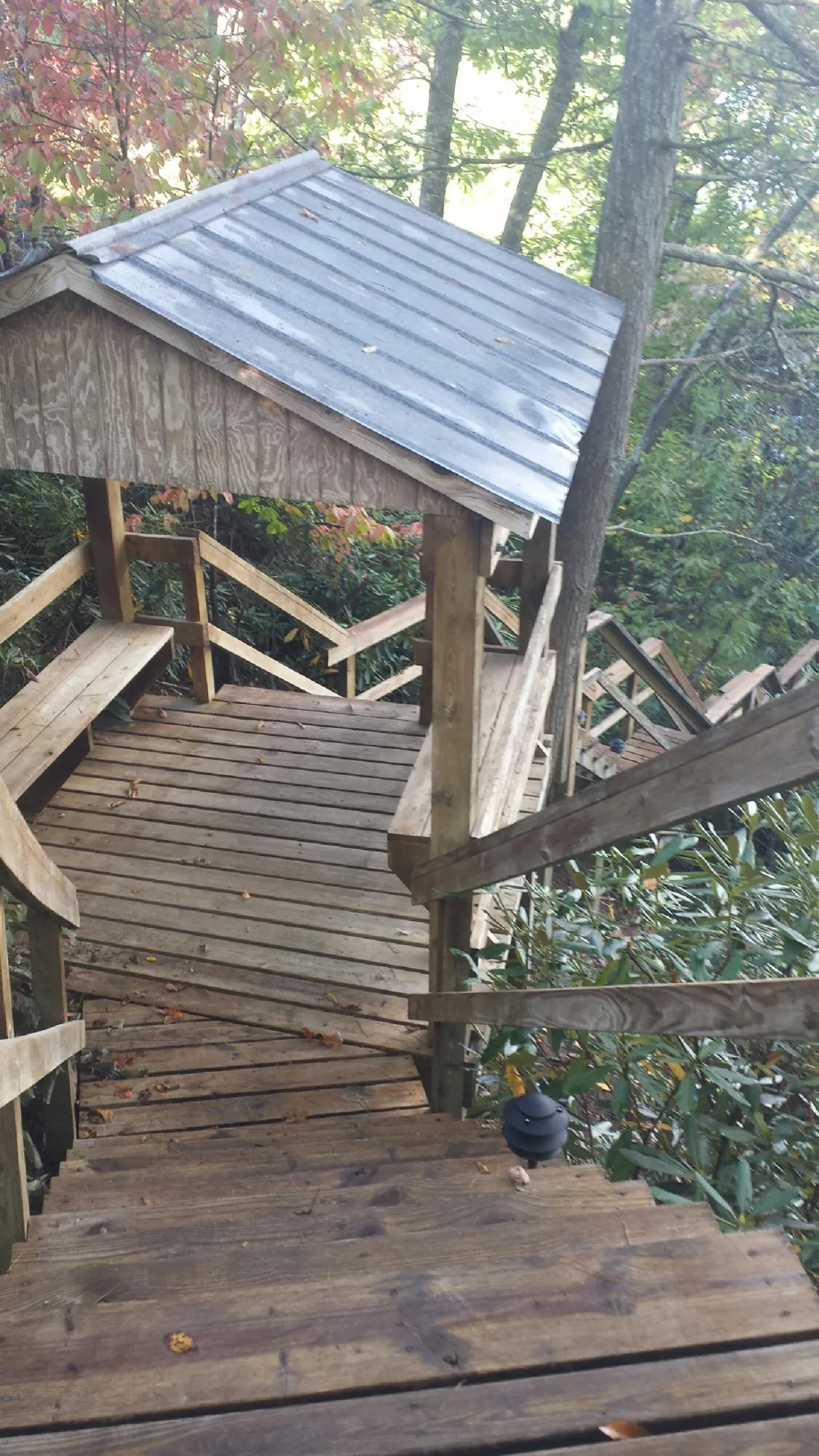 Metal roofed shelter over wooden steps on a wooded walkway — Skylight Repair & Installation work by our crew in South Londonderry