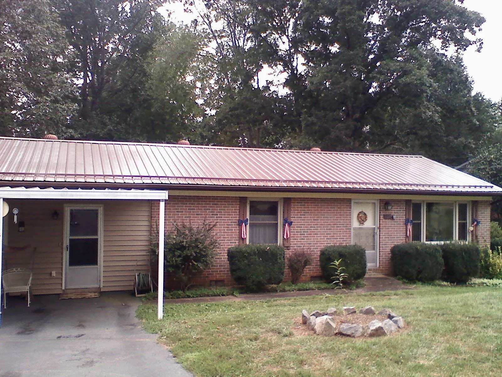 Bronze metal roof and carport on a brick ranch home — Roof Repair work by our crew in South Londonderry